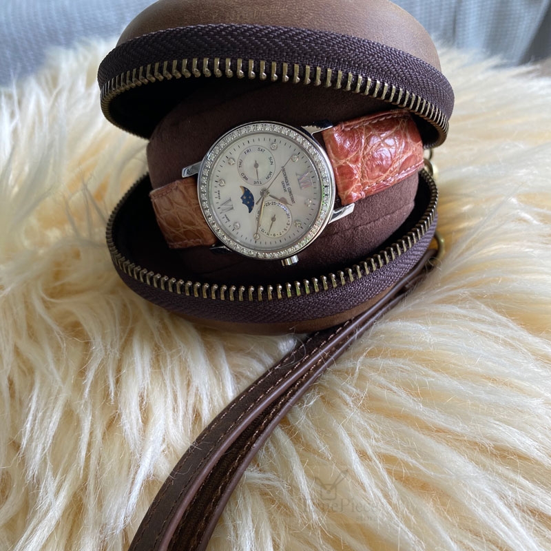 Opened donut shape watch travel case. A lady watch inside showing how the squeezable cushion can fit various watch band sizes.