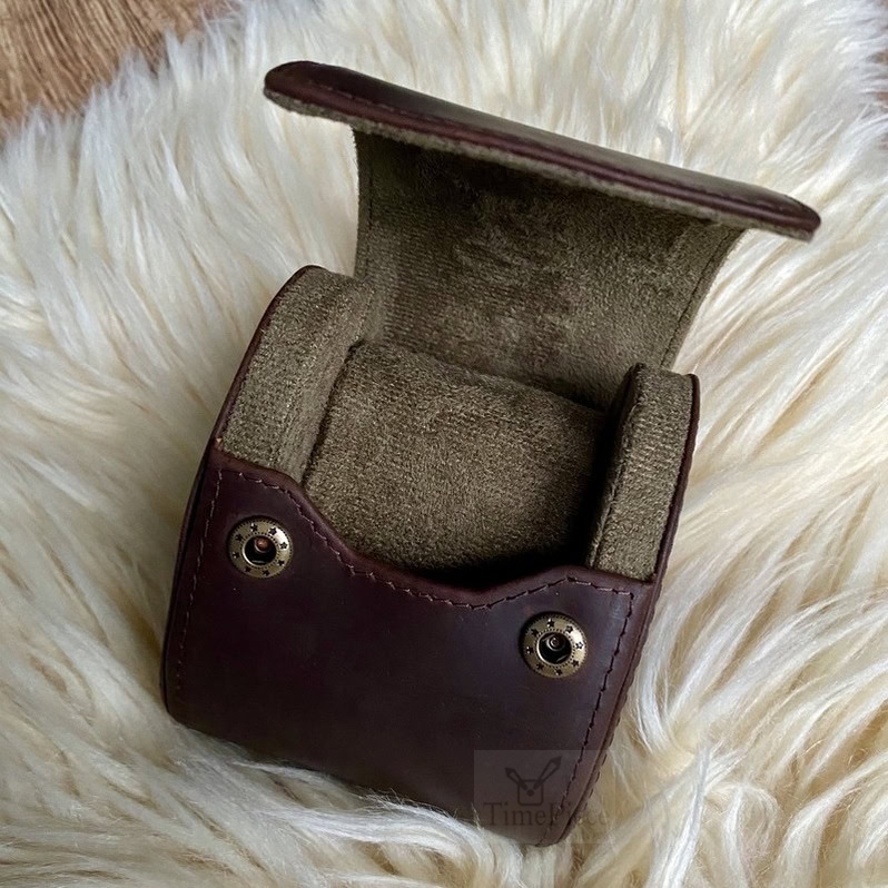 Opened retro coffee cowhide leather watch travel case. Showing the velvety inside with sliding watch cushion.